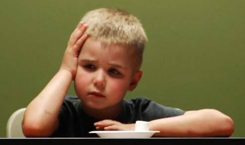 -01- 我儿子的堂哥暑假和寒假期间常来我家,在我家的时候,他只要稍有闲暇,就到处搜零食吃,常常因为吃了太多零食而没胃口吃饭被爷爷奶奶训。据了解,他在自己家的时候,妈妈对他零食管得很严,每天只有在固定的时间吃妈妈允许的量的零食,偶尔表现好或有别的例外情况会稍微有所放松。但很明显,他妈妈对他的严格控制,并没有让他发展出真正的自控力,一旦受控的条件不复存在,他就完全失控了。 在一篇文章里看到这样一个例子:商场里,一个小男孩站在一排玩具车前,眼睛放光,趁妈妈不注意,他在妈妈背后,狠狠踢了小汽车一脚,又把一排玩具车都推倒,才紧跑几步跟上妈妈……而这个孩子,一直是妈妈引以为豪地很懂事很有自控力的小男生。他的妈妈常常很自豪地向朋友宣扬自己的带娃妙招——延迟满足。孩子想要某样玩具,玩具就在手边也要等一会儿才给拿;想吃零食,必须努力表现才能得到…… 这个妈妈看得到孩子的克制,却看不到,由于长期以来需求得不到及时而充分的满足,他只能用用极端方式发泄自己的不满。 不少父母认为“不要马上满足孩子”、“要让孩子学会等待”,可以培养孩子的延迟满足能力,从而发展孩子的自控能力。然而,这其实是对“延迟满足”理论的误读。 -02- “延迟满足”理论起源于下面这个实验: 20世纪60年代,美国斯坦福大学的教授沃尔特·米歇尔设计了一个实验,实验的目的在于研究儿童什么时候发展出自控力。这个实验就是著名的“棉花糖实验“。实验者召集了一群孩子,最小的3岁6个月,最大的5岁8个月。实验中,实验者给被试儿童每人一颗棉花糖,孩子们被告知,他们可以马上吃掉这块棉花糖,但是假如能等待20分钟再吃,那么就能得到第二块棉花糖。结果,有的孩子急不可待,把糖马上吃掉了;有的孩子等了一会儿,也终于忍不住吃了;而有另一些孩子则耐住性子等了足够长的时间,最后他们得到了第二块棉花糖。 研究人员在十八年以后再考察当年那些孩子,有意外发现:当年“能够等待更长时间”的孩子,也就是说当年“自我延迟满足”能力强的孩子,在青春期的表现更出色。研究人员持续跟踪这些“孩子”直至他们中年,结果发现早年延迟满足能力强的人,大脑前额叶相对更为发达和活跃,而这个区域负责着人类最高级的思考活动。 这个实验结果让很多人认为延迟满足能力决定着一个人成功的大小,于是对此大加宣扬,以至于很多父母受到这个观点的影响,很多时候故意不满足孩子,以为这样的刻意训练就可以让孩子发展出更好的延迟满足能力。殊不知,他们其实是在伤害孩子自制力的发展。 -03- 首先,延迟满足能力发展的关键点在于“满足”,而不在于“延迟”。 在最初的“棉花糖实验”之后,2011年,另一个实验小组研究发现,平时比较容易得到棉花糖的孩子,更容易主动延迟满足;而平时经常无法轻易得到棉花糖的孩子,则更难做到对得到棉花糖的延迟满足。 相信作为成人的我们也有这样的体验,如果一样东西我们平时比较容易得到,那么我们对它的欲望就不会那么迫切,也就能为得到它而承受更多的等待。而如果我们被迫切想得到某个东西的强烈欲望占据,就很难能够保持理性的头脑去权衡付出与受益。而平时越是匮乏的东西,就越容易激发我们迫切想要得到它的欲望。 孩子也一样。如果一个孩子平时很难得到棉花糖,眼前的棉花糖就会激起他强烈的占有欲望,被欲望占据的强烈情绪会干扰孩子的理性思考,让他无法做出利益权衡(在试验中表现为孩子无法做出“再等20分钟就可以得到第二颗棉花糖”的判断),一旦没有他人控制,他就更可能迫不及待地马上占有这一稀缺物品。 所以,没有稳固的满足感,自制力就发展不起来,更谈不上延迟满足。 其次,延迟满足应该是主动延迟,而不是被动延迟。 1976年,米勒和蕾切尔小组发表论文指出:当孩子觉得是“自己在掌控着延迟的过程”,他想停止随时可以停止,那么他主动延迟的时间会更长;相反,如果孩子发现自己不能决定什么时候停止延迟,那么他的延迟时间会大幅缩短。 最新的神经科学研究对此的解释是:被动感,会激活愤怒情绪系统,进而干扰了自控能力。 也就是说,是否延迟满足,应该是孩子自己做出决定,而不是别人!这是延迟满足能力是否能得到发展的基础。然而大多数有意识训练孩子延迟满足能力的父母,都是基于父母自己的判断和决定。 再者,“父母是否可信”对孩子延迟满足能力的发展非常重要。 美国罗切斯特大学“延迟满足再研究”小组,于2012年发表了他们的成果:他们把实验改为两步。在第一步实验中告诉孩子,如果等待,他们将得到“更好的蜡笔”。第二步则沿用传统的棉花糖实验。实验者把孩子分成两组,A组由“可信的大人”主导,即在第一步中兑现了“更好的蜡笔”的承诺;而B组孩子则由“不可信的大人”主导,这个大人在第一步中食言了。结果在第二步的实验中,A组孩子延迟满足的平均时间达到了12分钟,而B组只有3分钟。 2012年的这个延伸实验结果告诉我们,如果孩子觉得父母可信,那么他们就更愿意配合父母的意志;反之,则配合更难。 -04- 基于以上三点对“延迟满足能力”的解读,如果父母希望孩子发展出较好的自制力,相应地要做到以下三点: 1. 及时回应并满足孩子的需求,让孩子有满足感。 所有真实的需求都是合理的,那些看似不合理的需求,往往是真实需求的变相表达。比如孩子没完没了地要买玩具,不买就哭闹撒泼,买回来又不好好玩,这背后,孩子真正需要的未必是玩具,有可能是父母的陪伴、关注、或以此来考验父母是否真的爱他,等等。 父母要尝试去体会孩子的感受,区分真实的需求和变相的需求。如果无法区分,在客观条件允许的前提下,不妨先满足孩子的表面需求,至少,这能部分满足孩子的需求。 2. 给孩子足够的自主空间。 自主是自控的前提,孩子越是自主,就越是自控。父母需要放手给孩子更多的空间,孩子认知范围内能自己做决定的事多放权让孩子自己去决定。 3.做可信的父母。 父母要言而有信。如果我们答应孩子吃完午饭就可以吃巧克力,那么午饭后就一定要给孩子巧克力;如果答应了孩子周末陪孩子去公园,那么周末就一定抽时间带孩子去公园……孩子感到父母可信,才会更愿意配合父母,因为他对后面会发生什么是有预知的,这种预知感会给孩子带来掌控感,他知道,到时间就一定能得到自己想要的。 “可信”的内涵十分丰富,除了“言而有信”之外,还包含着第一点说的“对需求的回应和满足”以及父母坦诚的态度,这些都形成了孩子对父母信任感的基础。 -05- 延迟满足能力无需刻意培养。 孩子的成长中,天然存在着许许多多的延迟满足。比如,肚子饿了,却不能马上吃到饭;想去游乐场玩,爸爸妈妈却没时间带他去;想找小伙伴玩,小伙伴却不在家;看电视的时间到了,动画片却还没演完,必须要等到明天再看……这些种种无时无刻不在训练着孩子的延迟满足能力,足矣!我们无需再人为地制造延迟满足的条件去刻意训练,这反而可能有负面效果。 如果孩子的需求是合理的,当孩子表达了意愿,父母就应该及时满足。这时候如果父母故意做出延迟满足的反应,要让孩子为此付出努力、不断争取后再满足,也许这样确实会让孩子明白“努力奋斗才有收获”的道理,但长此以往会给孩子一个感觉:妈妈满足我是需要条件的,妈妈的爱就需要条件的,我的需求不见得一定要满足。那么孩子可能会在辛苦付出的路上一去不返,却不能坦然享受辛苦的成果,也不能坦然接受他人的爱,直接影响到孩子的幸福感。 如果孩子的要求不合理,我们应以温柔而坚定地态度直接否定和拒绝孩子,让孩子在需求面前分清对错,而不是用延迟来干扰孩子的判断。 当然,对于什么是合理需求、什么是不合理的要求,也但愿我们能够拥有足够的智慧去区分它们。 记得,延迟满足的关键,是“满足”,而非“延迟”。